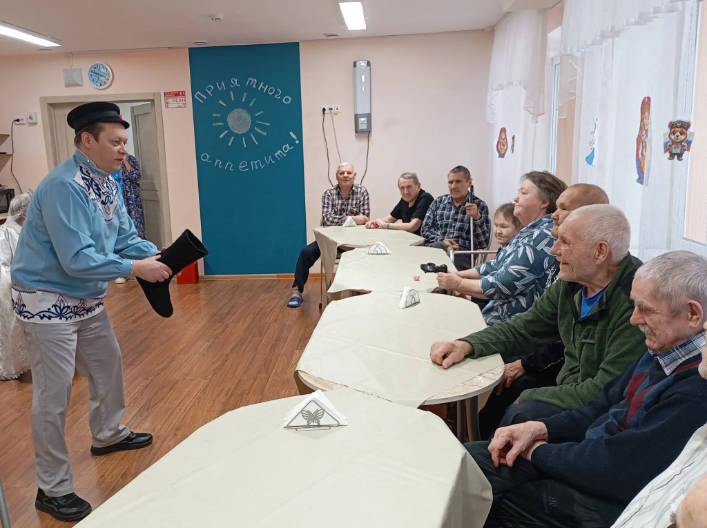 ведущий с валенком показываает.png