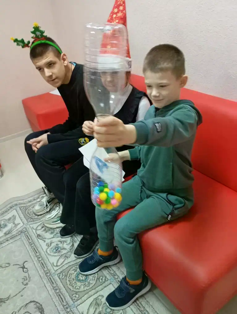 конструкция из бутылок пластиковых внизу шары двоя мальчиков сидят.png