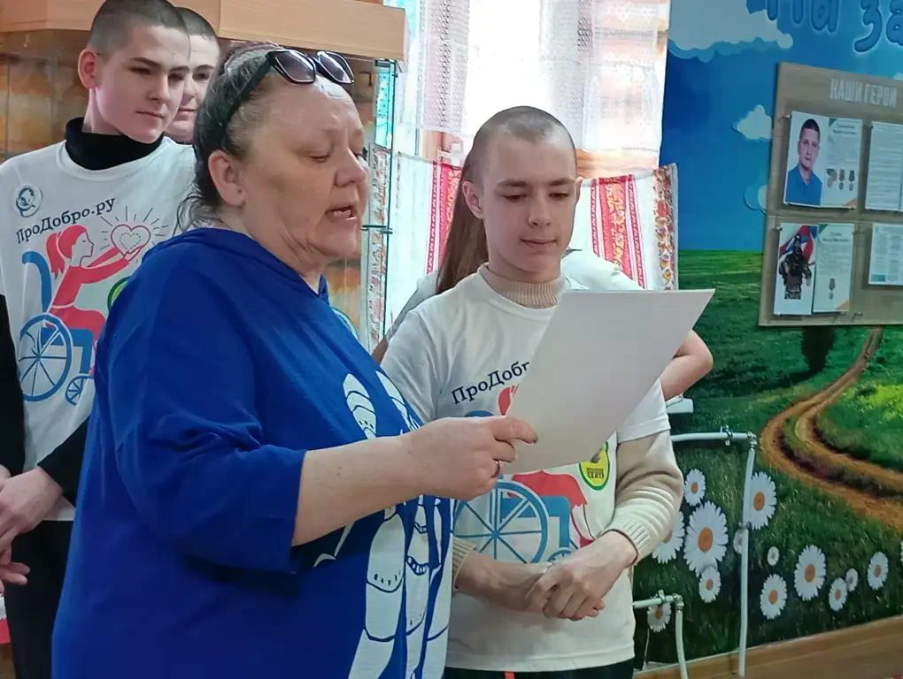 преподователь с учениками зачитывают строки из книг.png