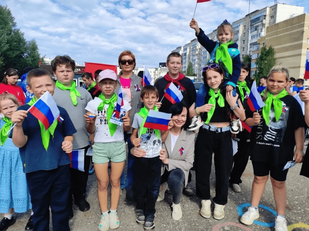 много детей стоят с флагами 