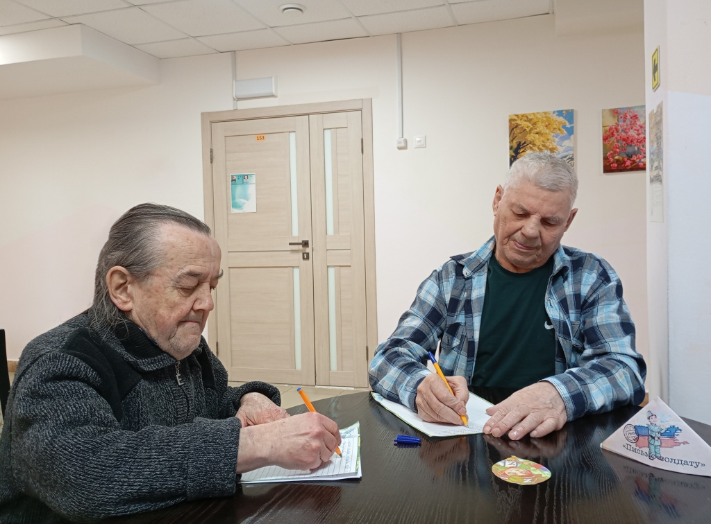 двоя мужчин уже дописывают письма солдатам 
