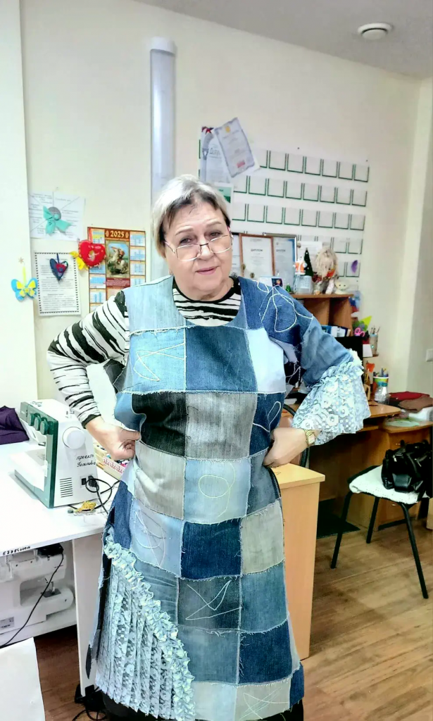 мастер труда стоит в изделии из клочьев ткани.png