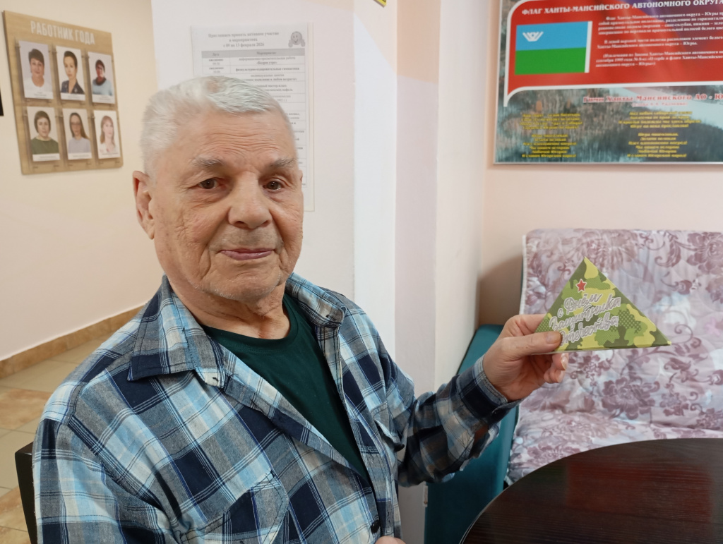 мужчина улыбается с письмом в виде пилотки 