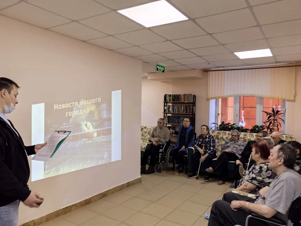 граждане старшего поколения смотрят новости нашего города ведущий слайд шоу показывает.png