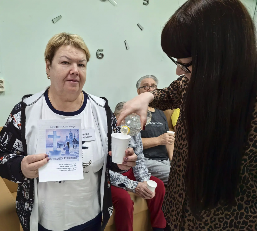 наливают женщине святой водички.png