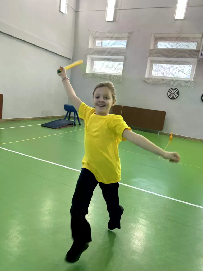 девочка радостная что прибежала на финиш с палкой в руке.png