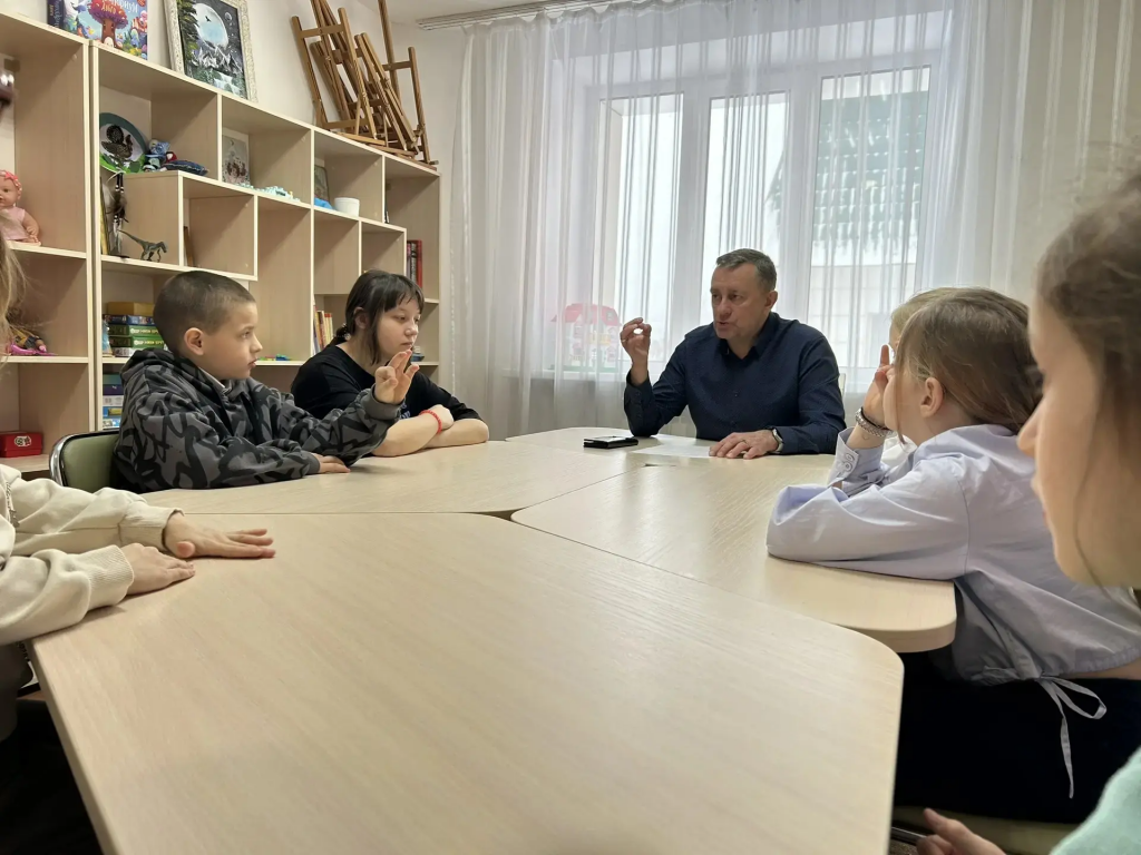 дети сидят с воспитателем он отвечает на вопросы.png